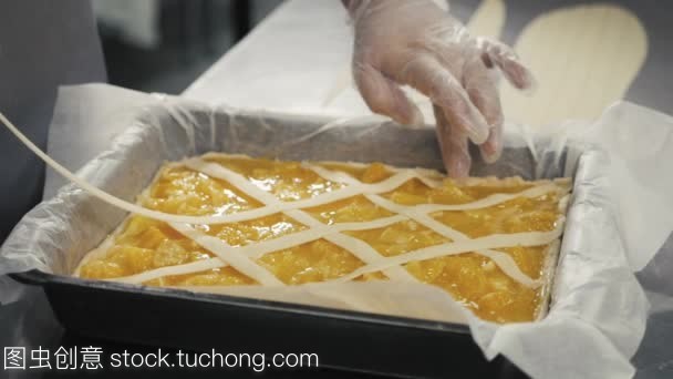 人準備水果橙色檸檬餡餅在廚房桌上, 最后的裝飾在手套, 餐廳廚房烘焙產(chǎn)品工廠
